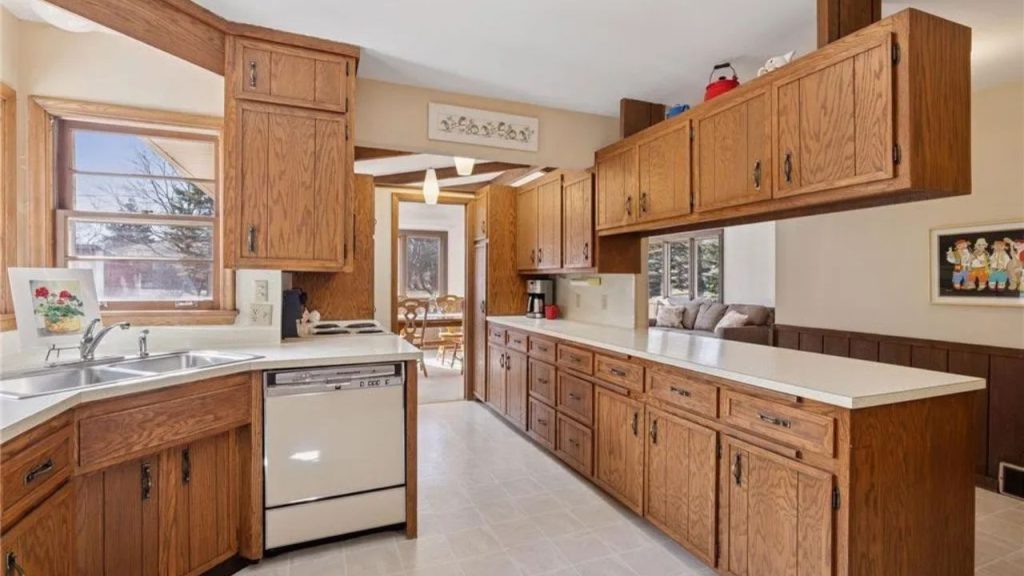 Galley kitchen with oak cabinets, white countertops, and a warm, connected layout.
