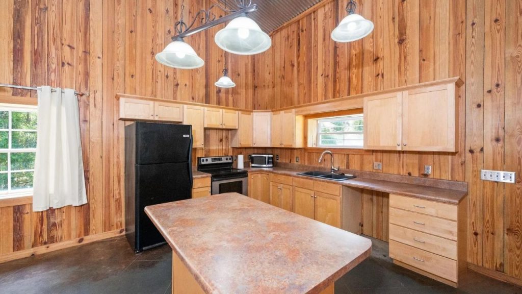 Warm wood kitchen with island and black appliances.