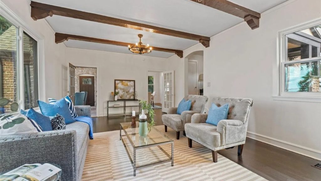 Bright living room with beam ceiling and open entry view.