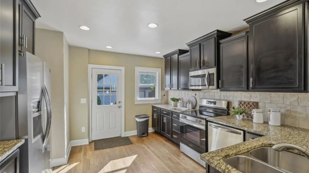 Modern kitchen with dark cabinets and stainless appliances.