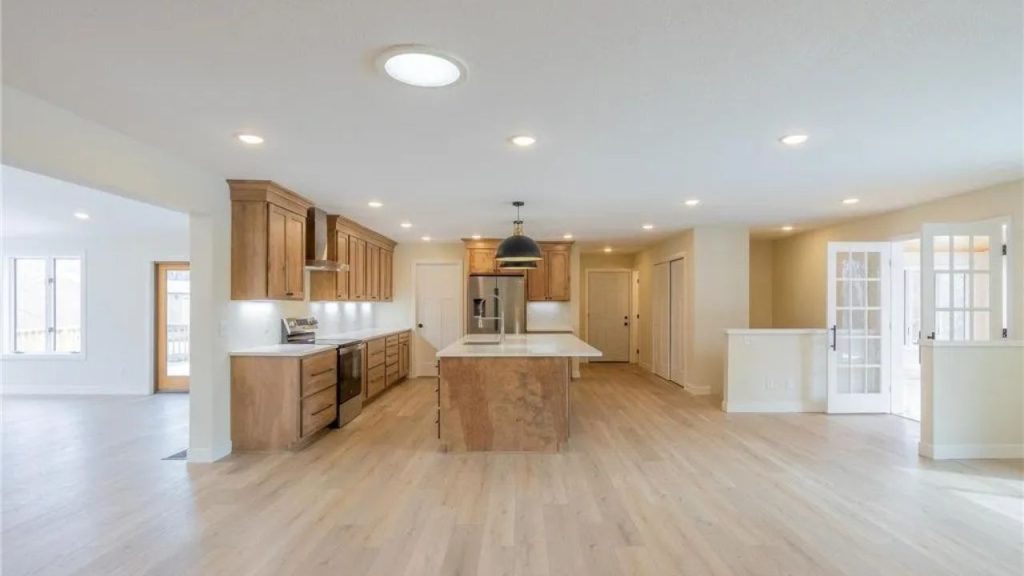 Open kitchen with wood cabinets, center island, and French doors nearby.