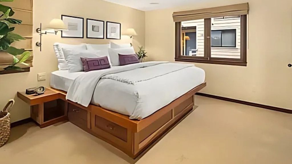 Cozy bedroom with platform bed, built-in drawers, and wall-mounted lamps.