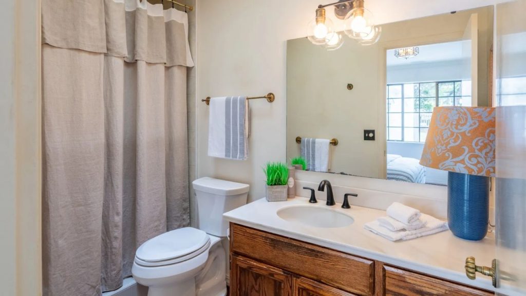A tranquil bathroom with warm wood tones and soft lighting.
