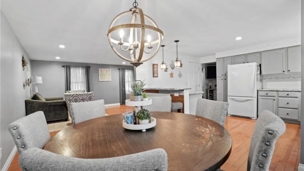 Cozy open-concept dining and kitchen with rustic lighting and grey cabinetry.
