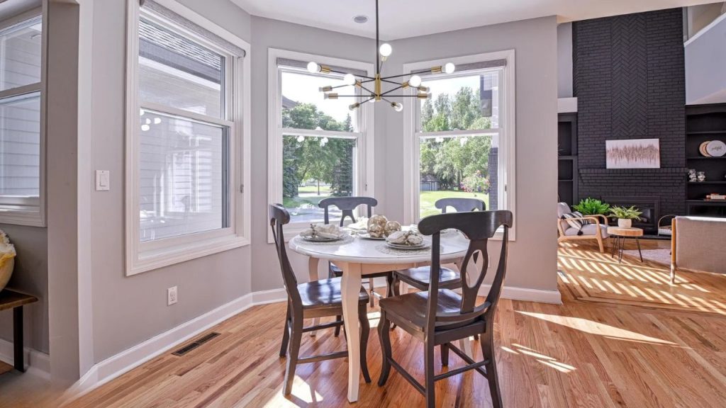 Sunny breakfast nook with round table and large windows.