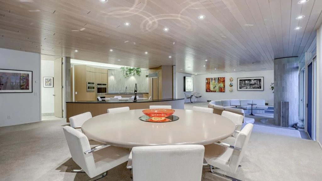 Open kitchen and dining with curved island and cozy sunken lounge.
