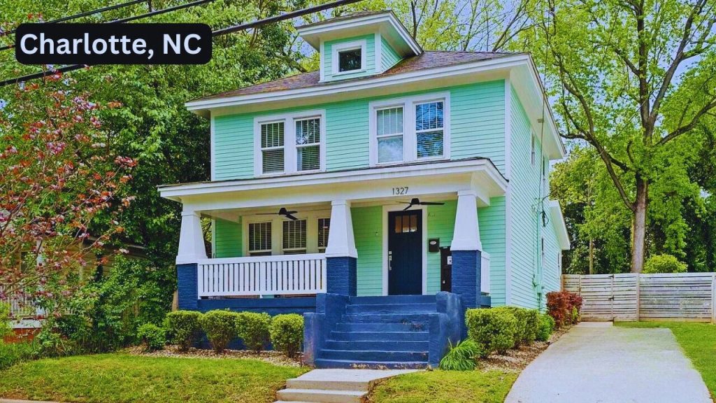 Mint-green two-story home with a wide front porch and navy accents.