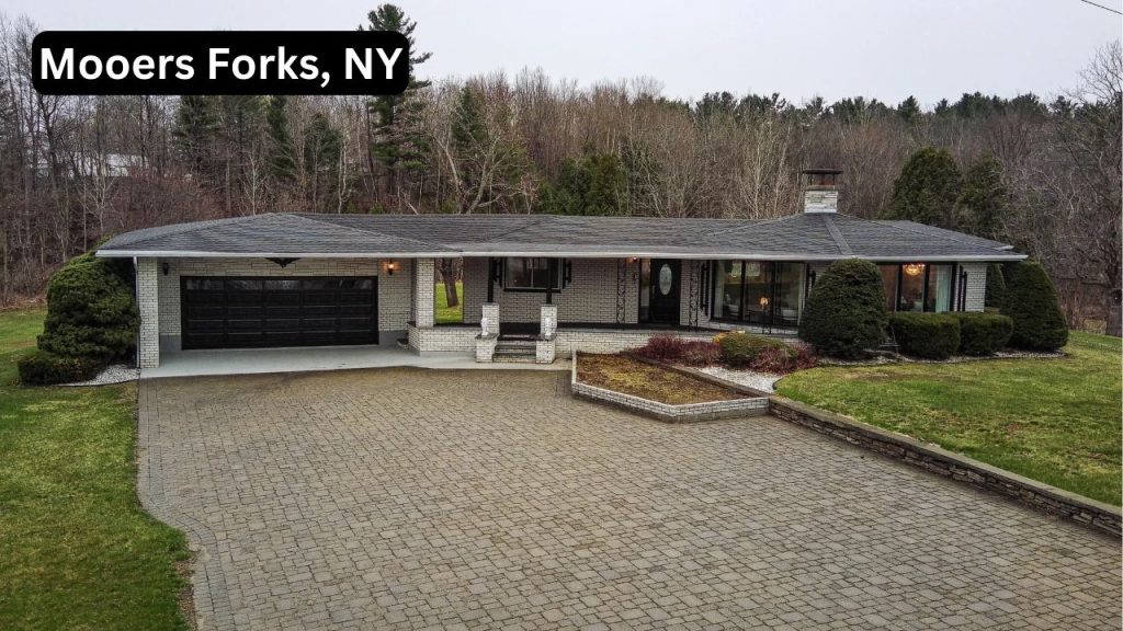 Spacious ranch-style home with a large driveway, attached garage, and landscaped yard in Mooers Forks, NY.
