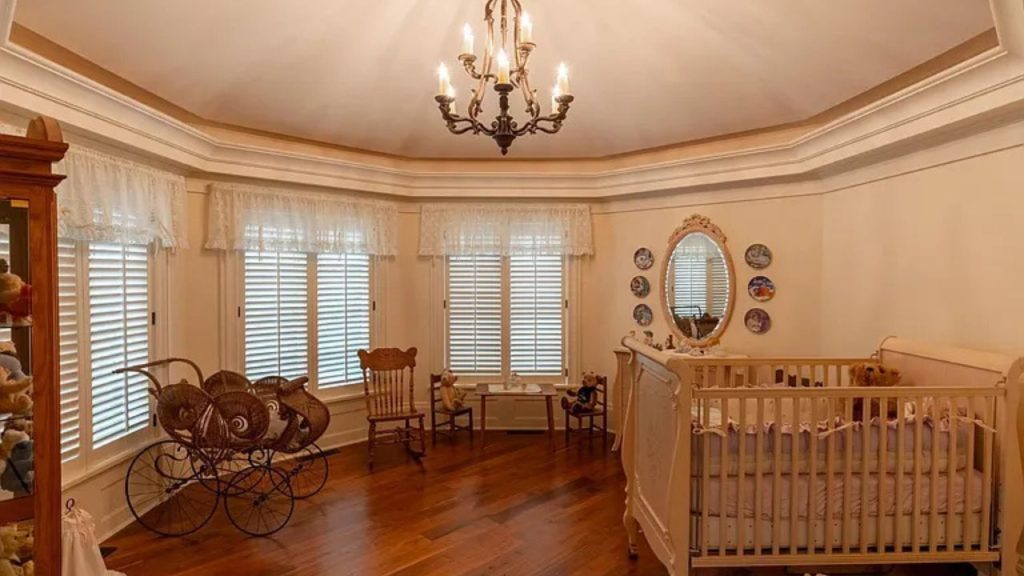 A cozy nursery with a crib, chandelier, and vintage decor.