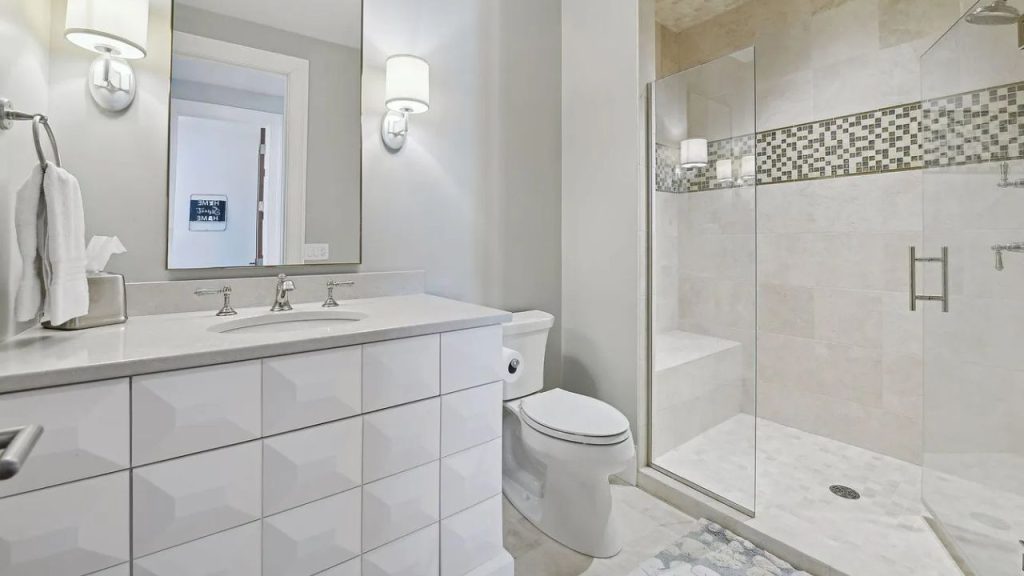 A calm bathroom with a tiled vanity and glass shower.