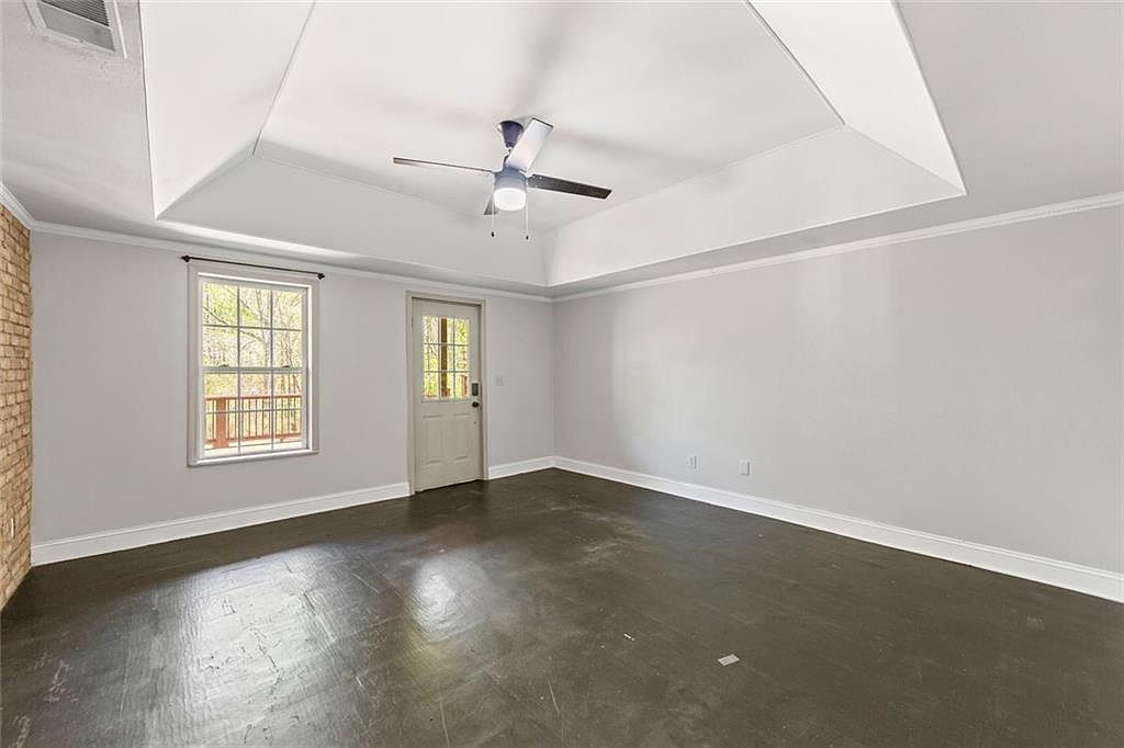Spacious living room with dark flooring and tray ceiling