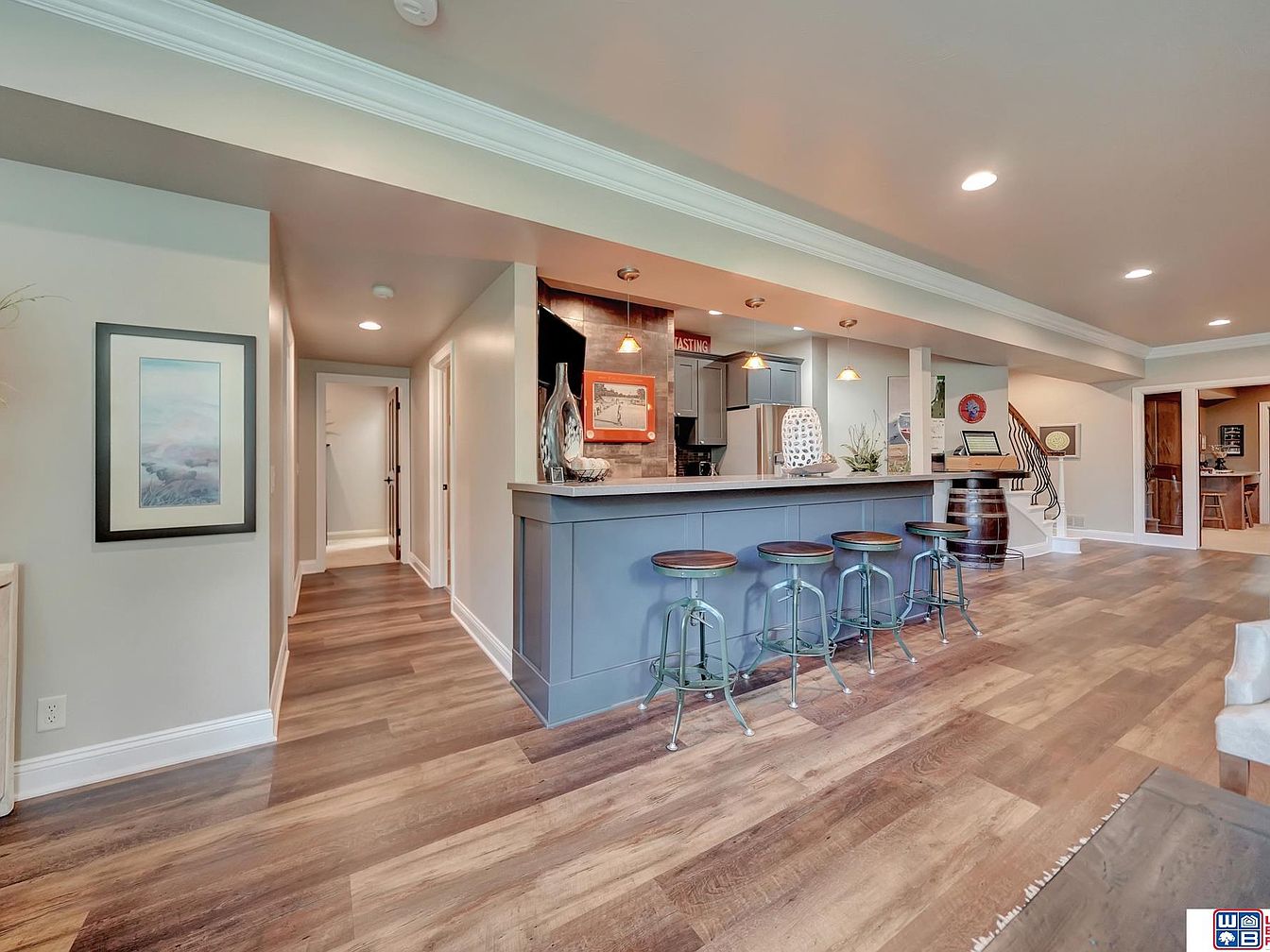 Home bar with four stools and wooden flooring