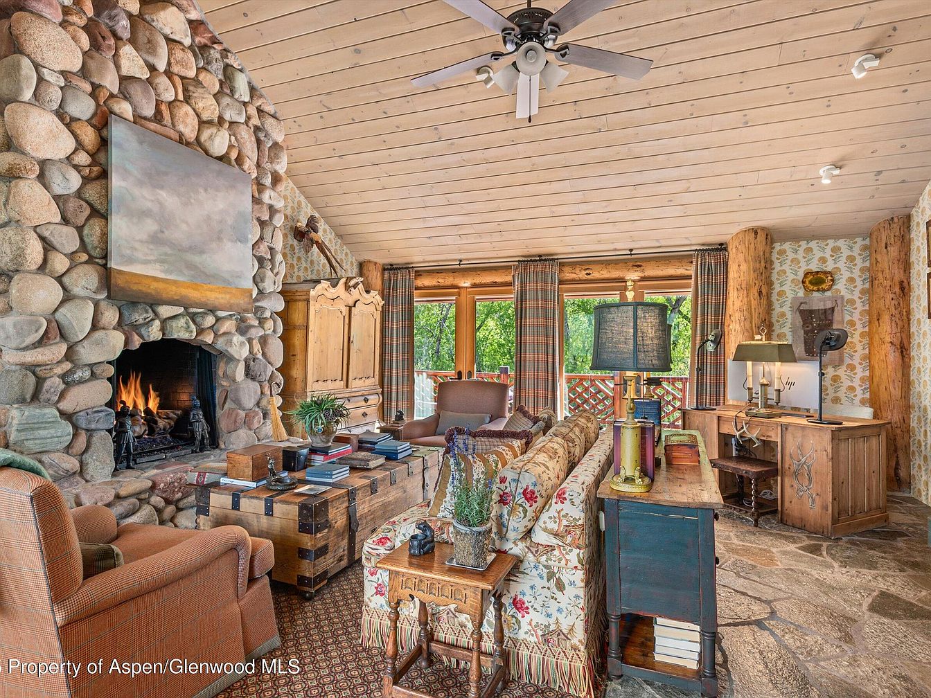 Cozy living room featuring stone fireplace and rustic decor