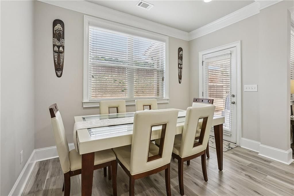 Dining area with modern table and chairs near window and door