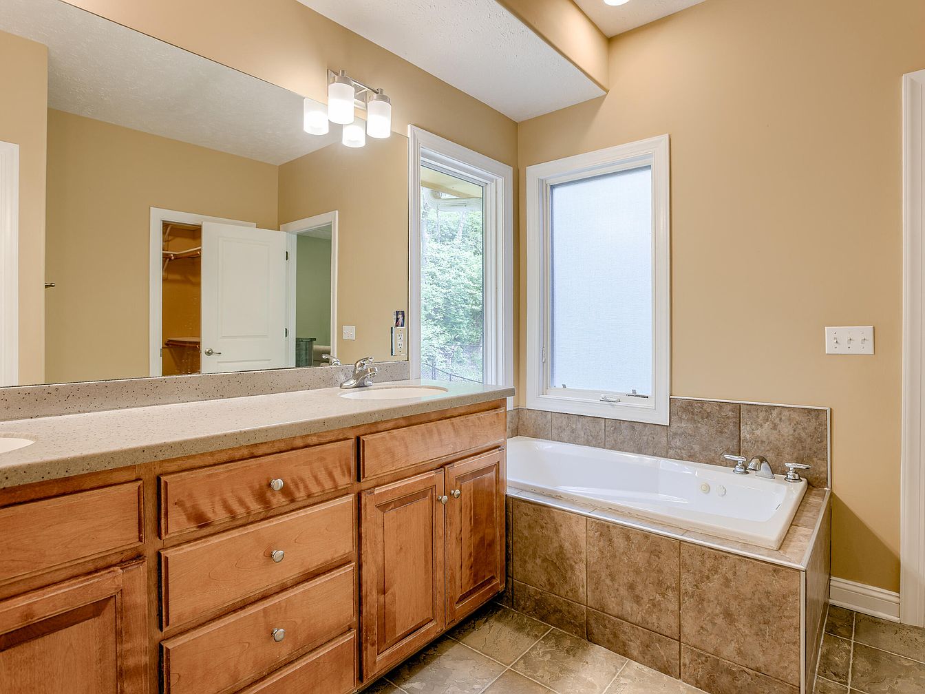 Bathroom vanity and corner bathtub with large window