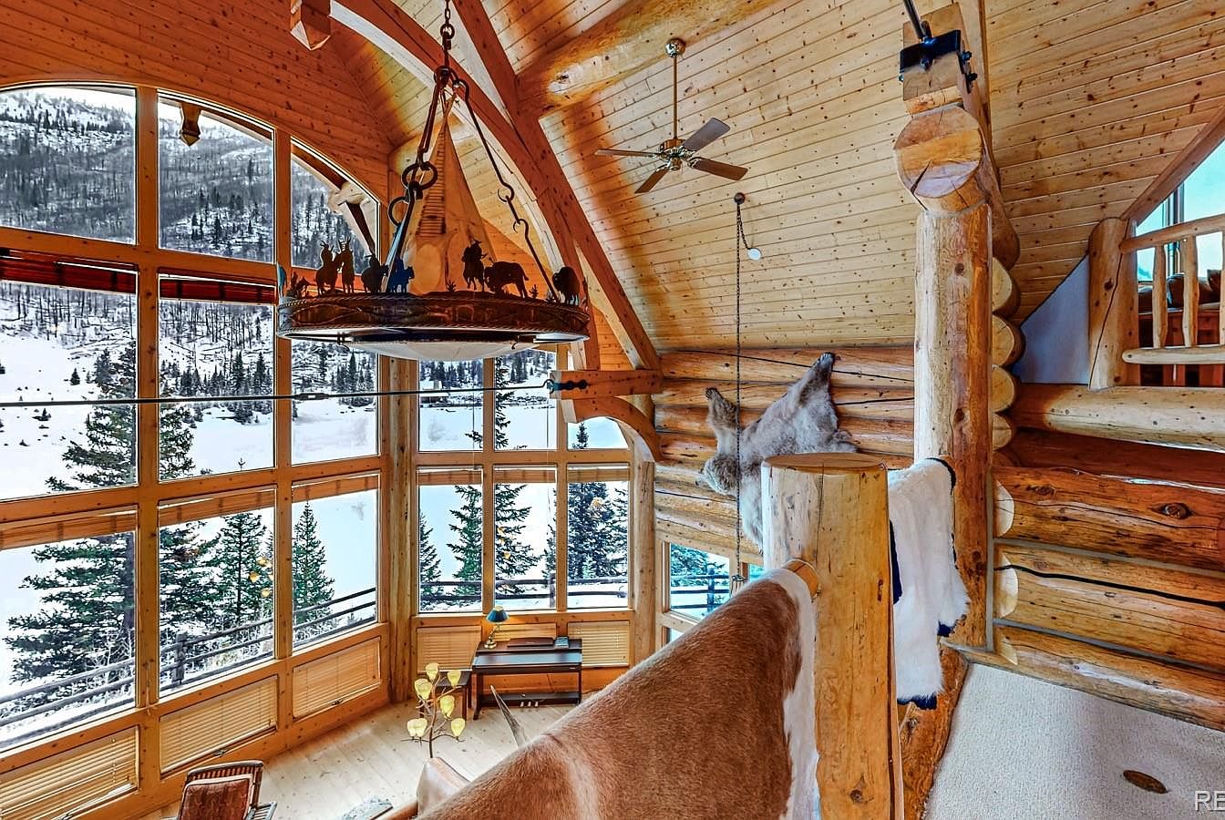 Rustic living room with large windows and wooden beams