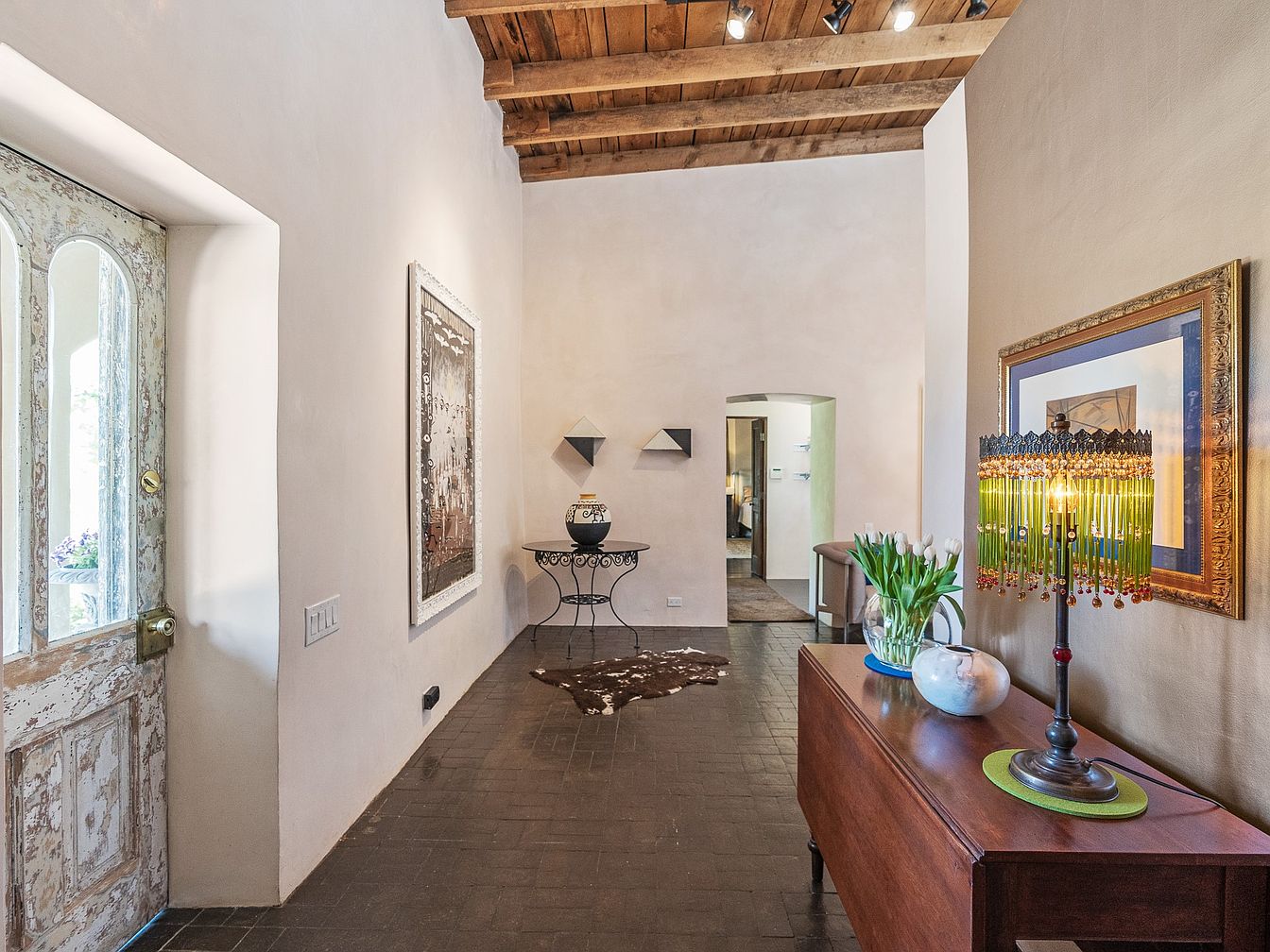 Entryway with rustic door and wooden ceiling
