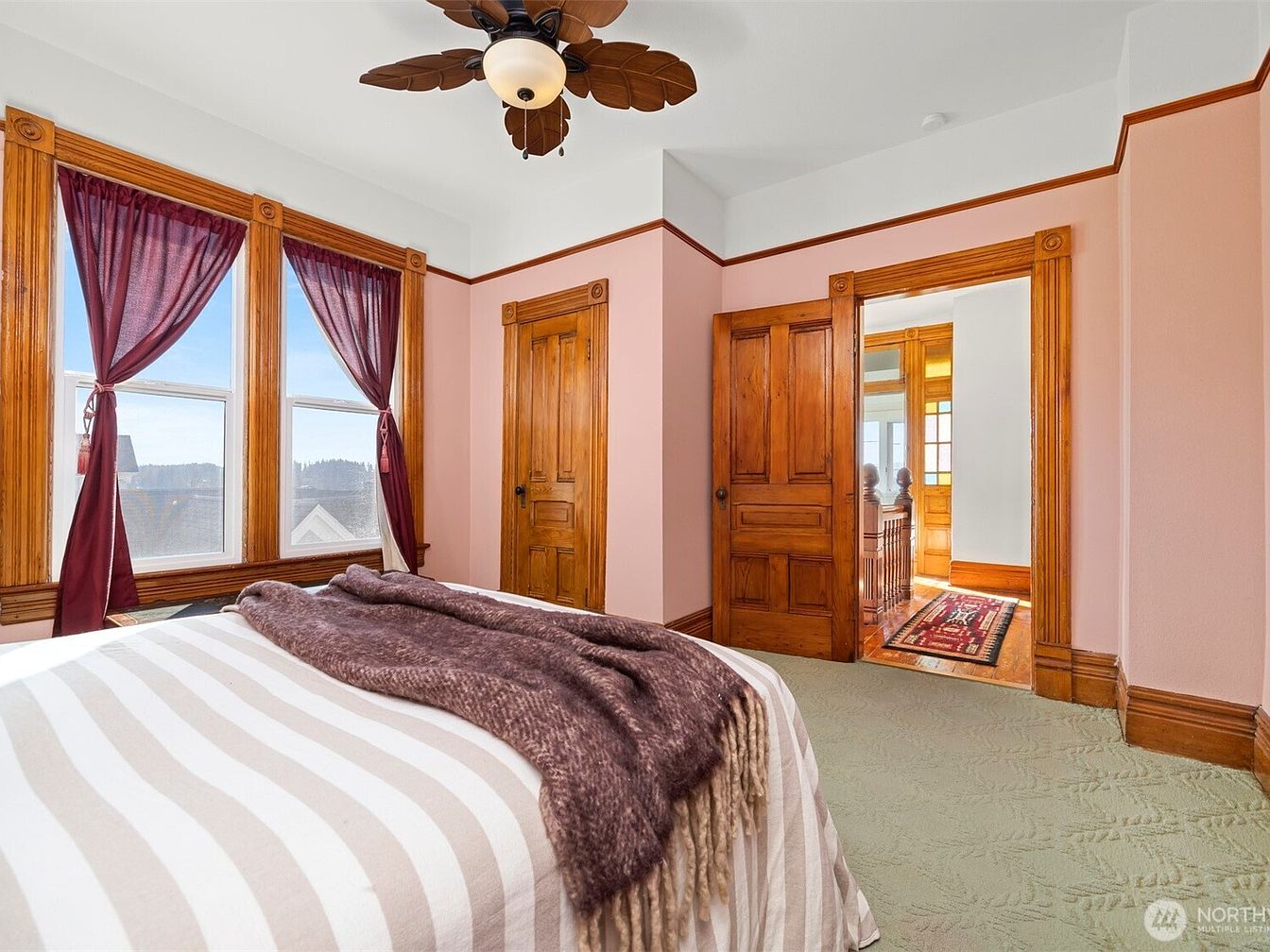Bedroom with wooden doors and burgundy curtains