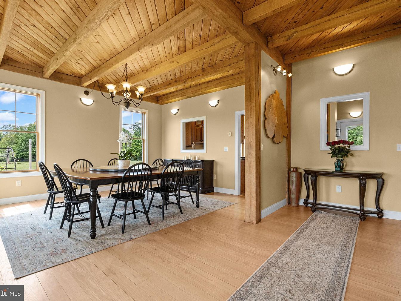 Dining room with wooden ceiling and black chairs around a wooden table